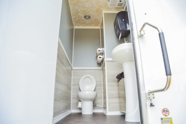 Climate Controlled Comforts of Home 2-Stall Restroom Trailer interior with toilet and sink